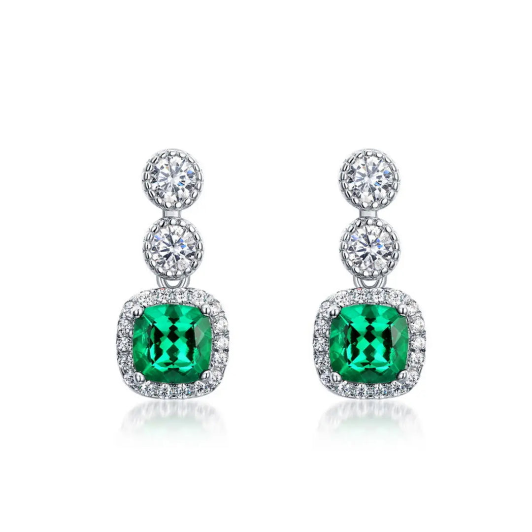 Cushion-cut emerald drop earrings crafted for brilliance and emotional harmony.