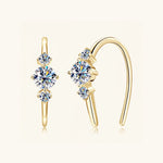 Gold moissanite jewelry earrings with three stones symbolising confidence and love.