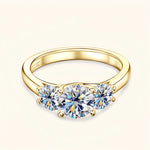 Gold moissanite engagement ring with three stones symbolising love, loyalty and balance.