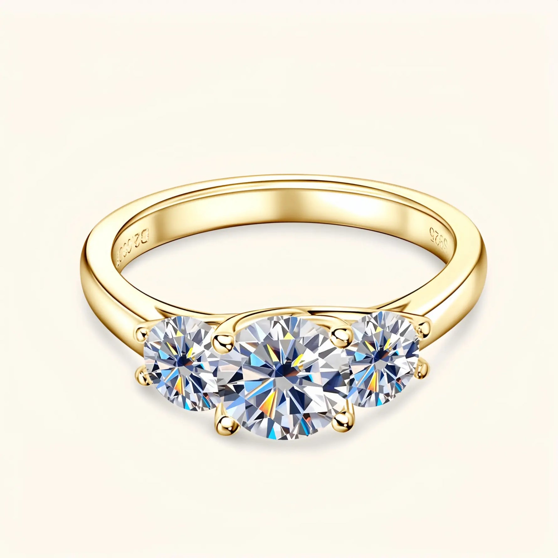 Gold moissanite engagement ring with three stones symbolising love, loyalty and balance.