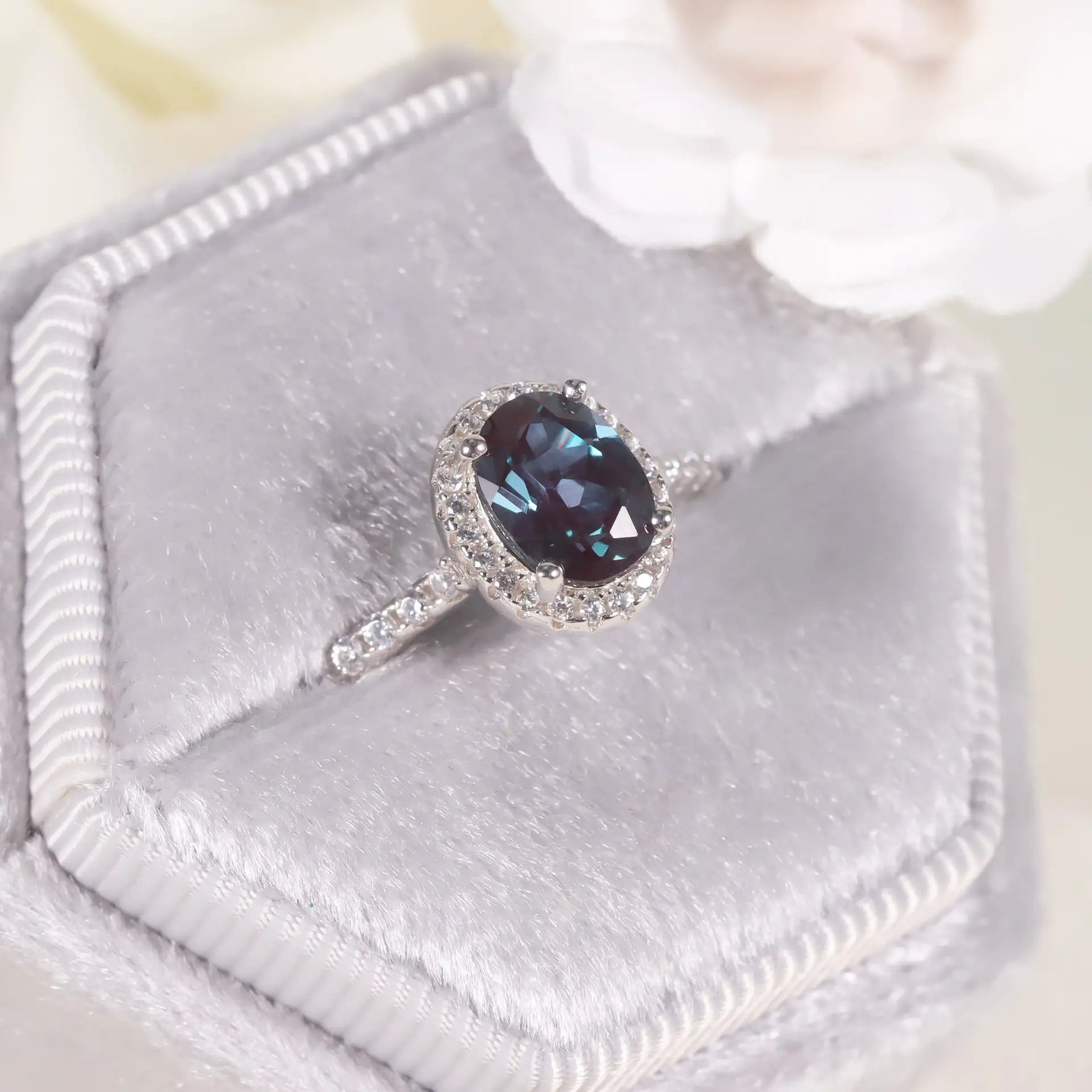 Halo alexandrite ring reflecting dual light and transformation, handcrafted by Minerva Jewelry.