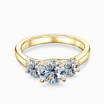 Gold moissanite engagement ring with three stones symbolising love, loyalty and balance.