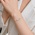 Yellow gold tone moissanite station bracelet worn on the wrist