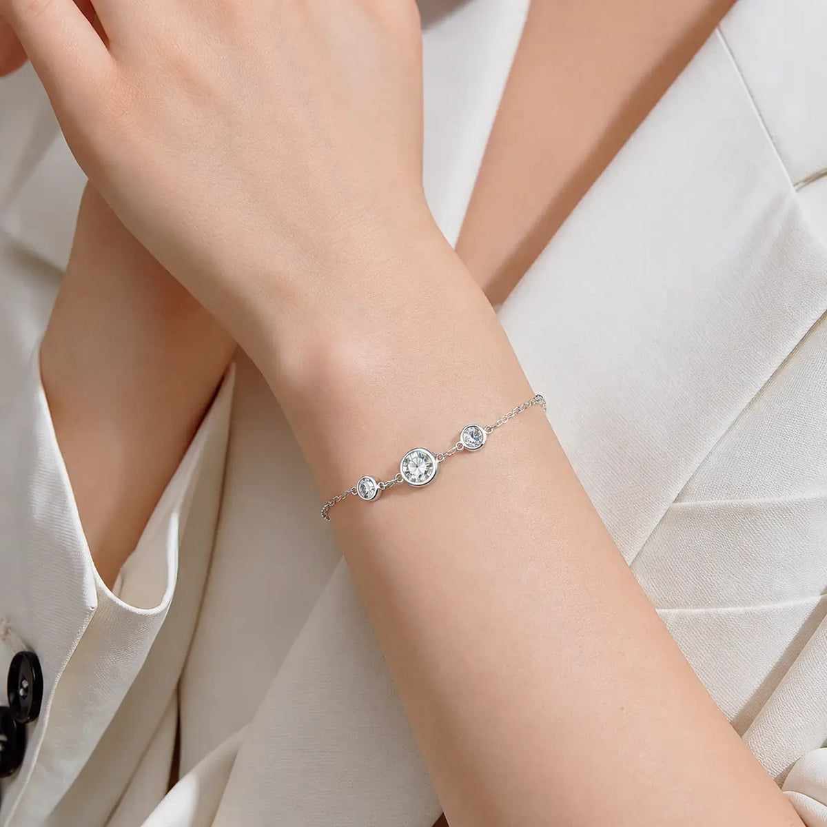 Yellow gold tone moissanite station bracelet worn on the wrist
