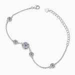 Silver tone bezel-set moissanite station bracelet worn on the wrist