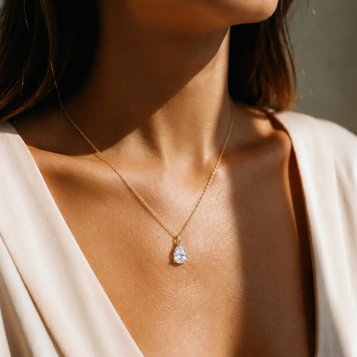 Pear-cut moissanite solitaire pendant on a fine chain.