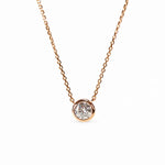 Single round moissanite in a bezel setting with the chain connected at both sides.