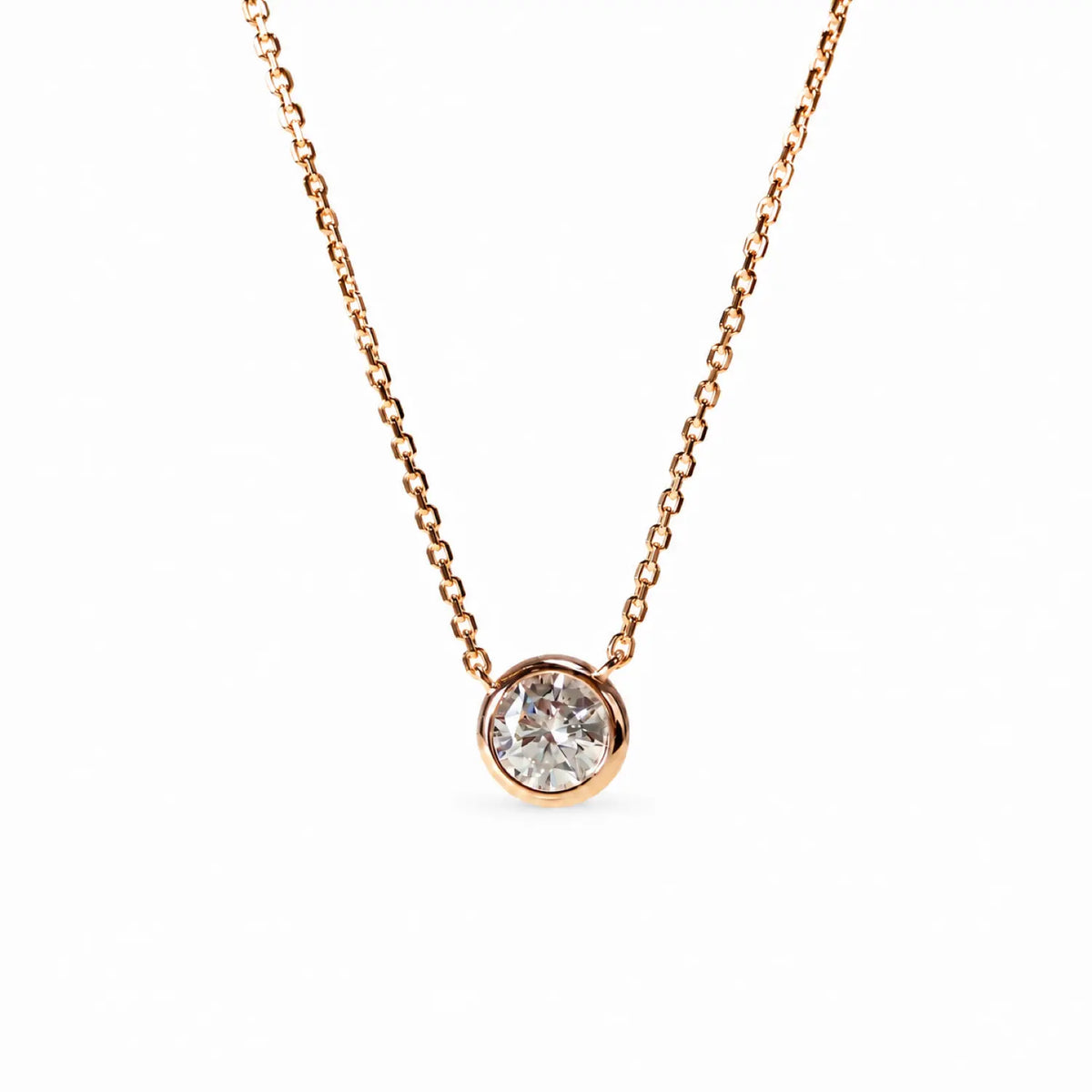 Single round moissanite in a bezel setting with the chain connected at both sides.