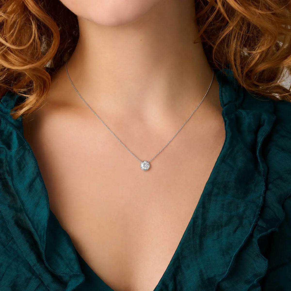 Single round moissanite in a bezel setting with the chain connected at both sides.