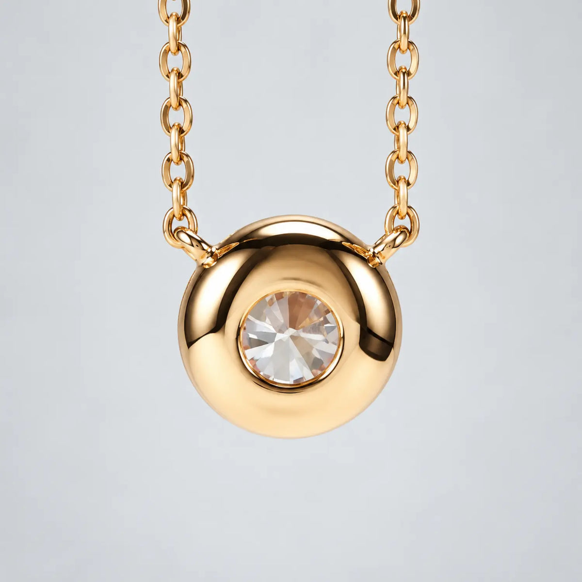 Single round moissanite in a bezel setting with the chain connected at both sides.