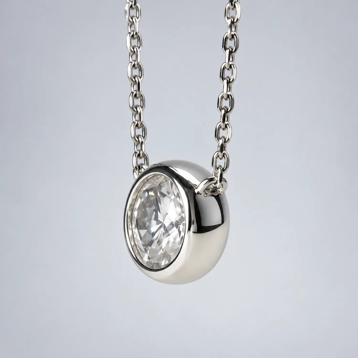 Single round moissanite in a bezel setting with the chain connected at both sides.