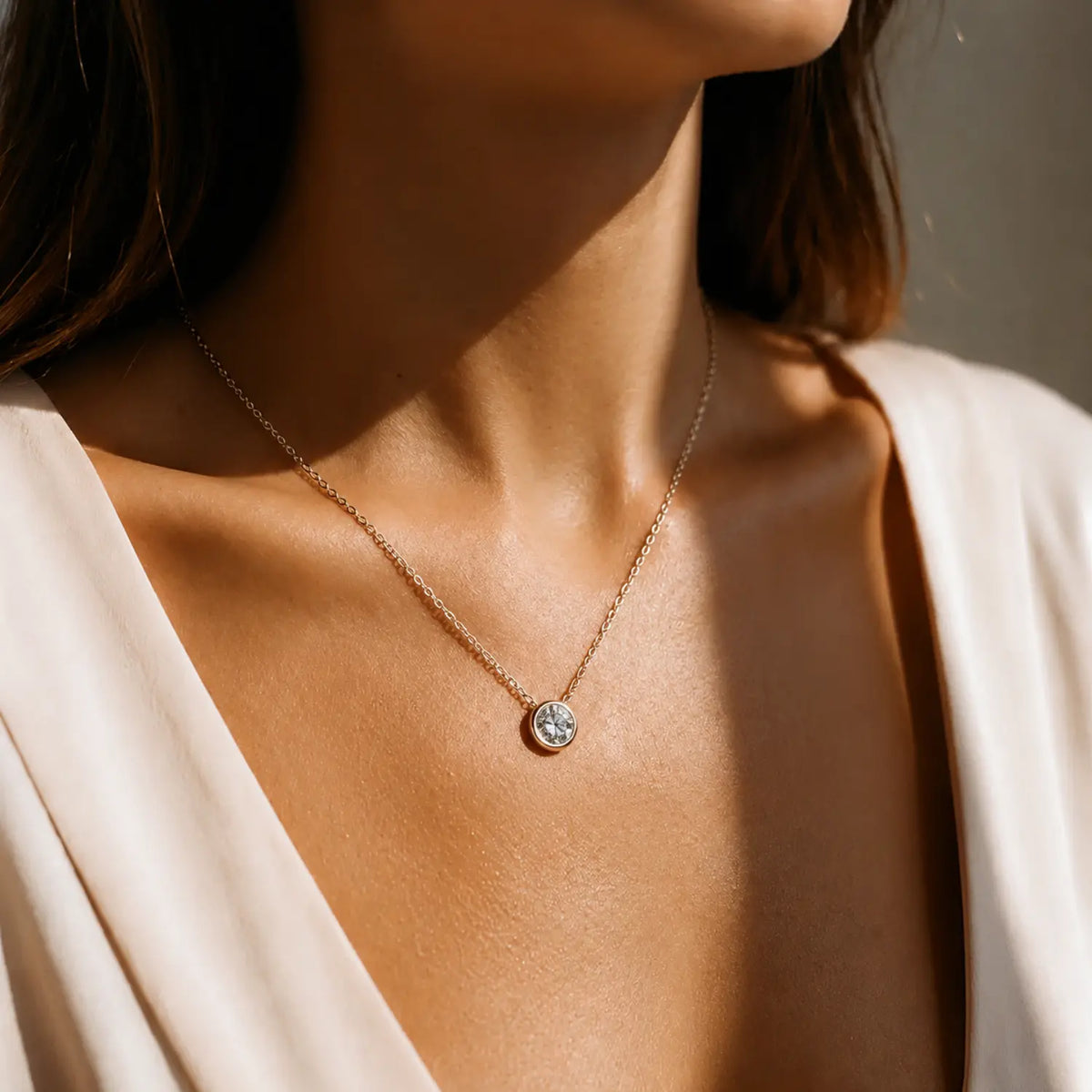 Single round moissanite in a bezel setting with the chain connected at both sides.