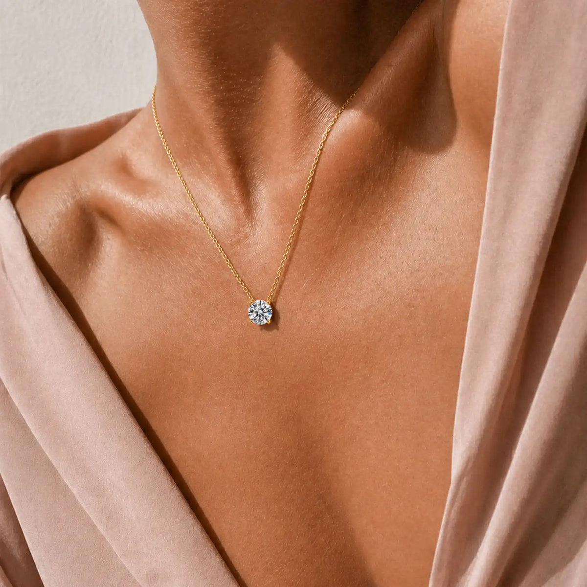 Round moissanite solitaire necklace with a four-prong setting and chain attached at both sides.