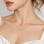 Three round moissanite stones in individual bezel settings arranged horizontally on a chain.
