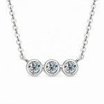 Three round moissanite stones in individual bezel settings arranged horizontally on a chain.
